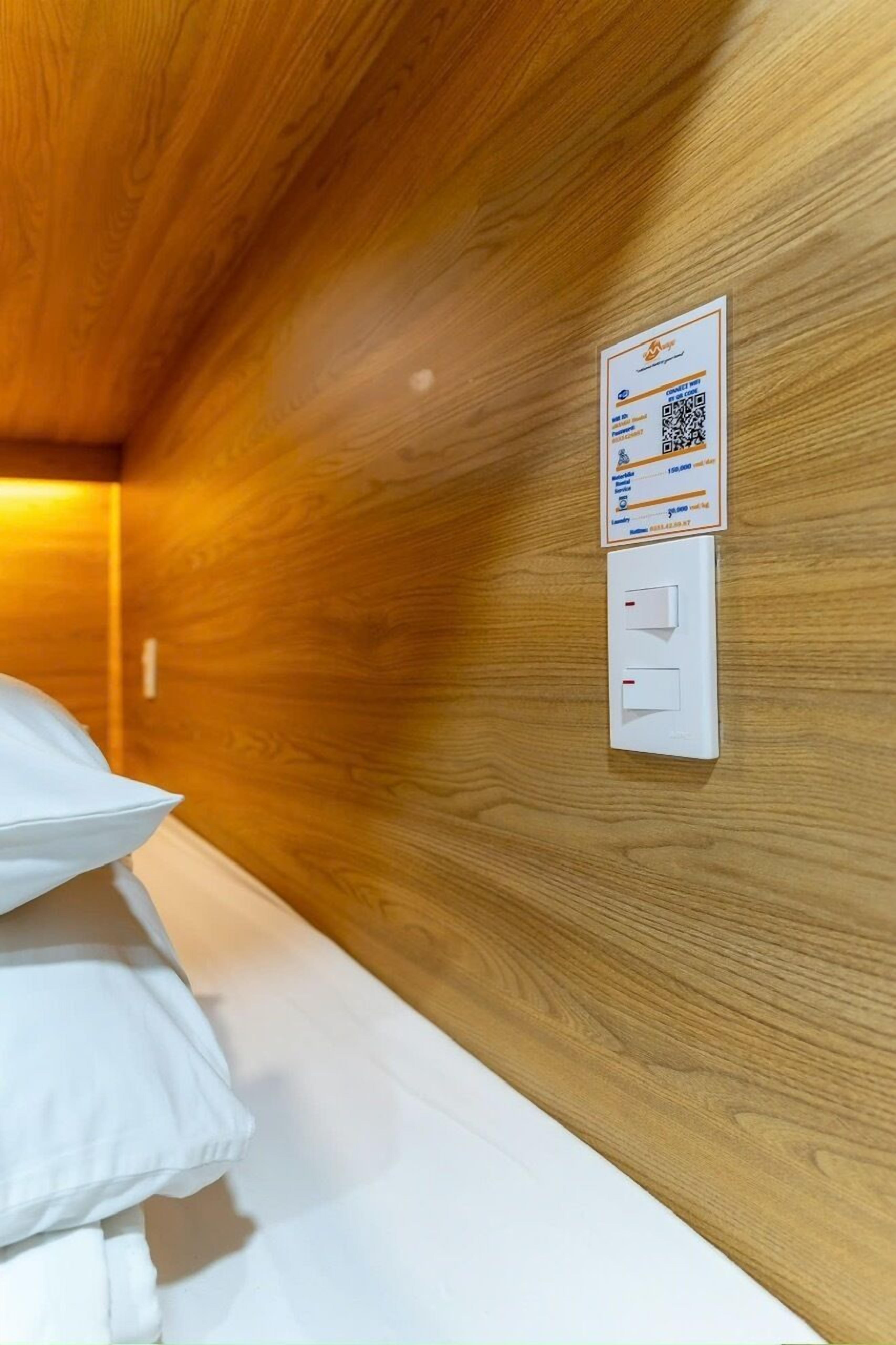 A wooden wall with a QR code and two switches, likely for room control.