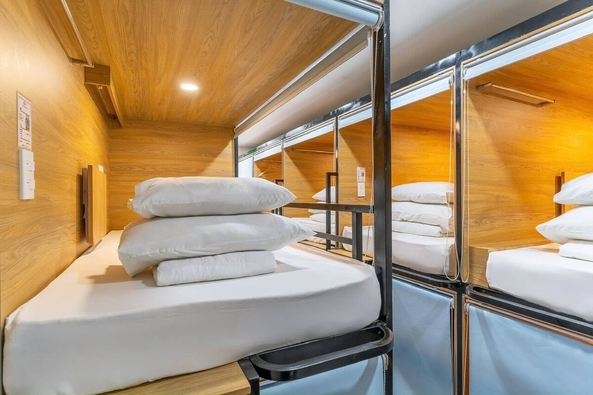 A bunk bed room with wooden walls and metal railings.