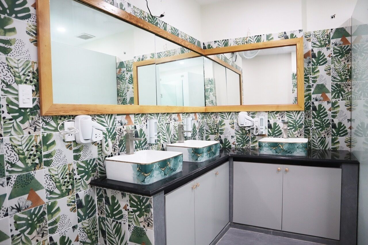 Une salle de bain avec deux lavabos, un grand miroir et un meuble de rangement.