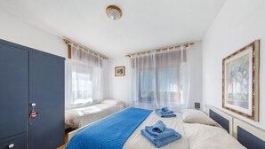 A bedroom with two beds, a wardrobe, and a painting on the wall. - Room 'Abeti' with Mountain View (San Pietro di Cadore)