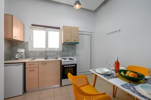 A compact kitchen with a dining area, including a sink, stove, and cabinets.