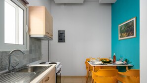 Une cuisine de taille réduite, équipée d’un évier, d’une cuisinière et d’armoires en bois.