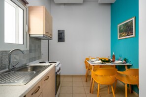 A compact kitchen with a sink, stove, and wooden cabinets.