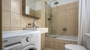 A modern bathroom with a washing machine, a glass-enclosed shower, and a toilet. - Apartment 'Rhodes Sea Ialysos' with Balcony, Wi-Fi and Air Conditioning (Ialisos)