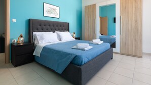 A bedroom with a large bed, a nightstand, a wall-mounted picture, and a wardrobe. - Apartment 'Rhodes Sea Ialysos' with Balcony, Wi-Fi and Air Conditioning (Ialisos)