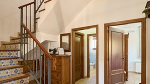 Una escalera con peldaños decorados, un armario de madera y una puerta que da a otra habitación.