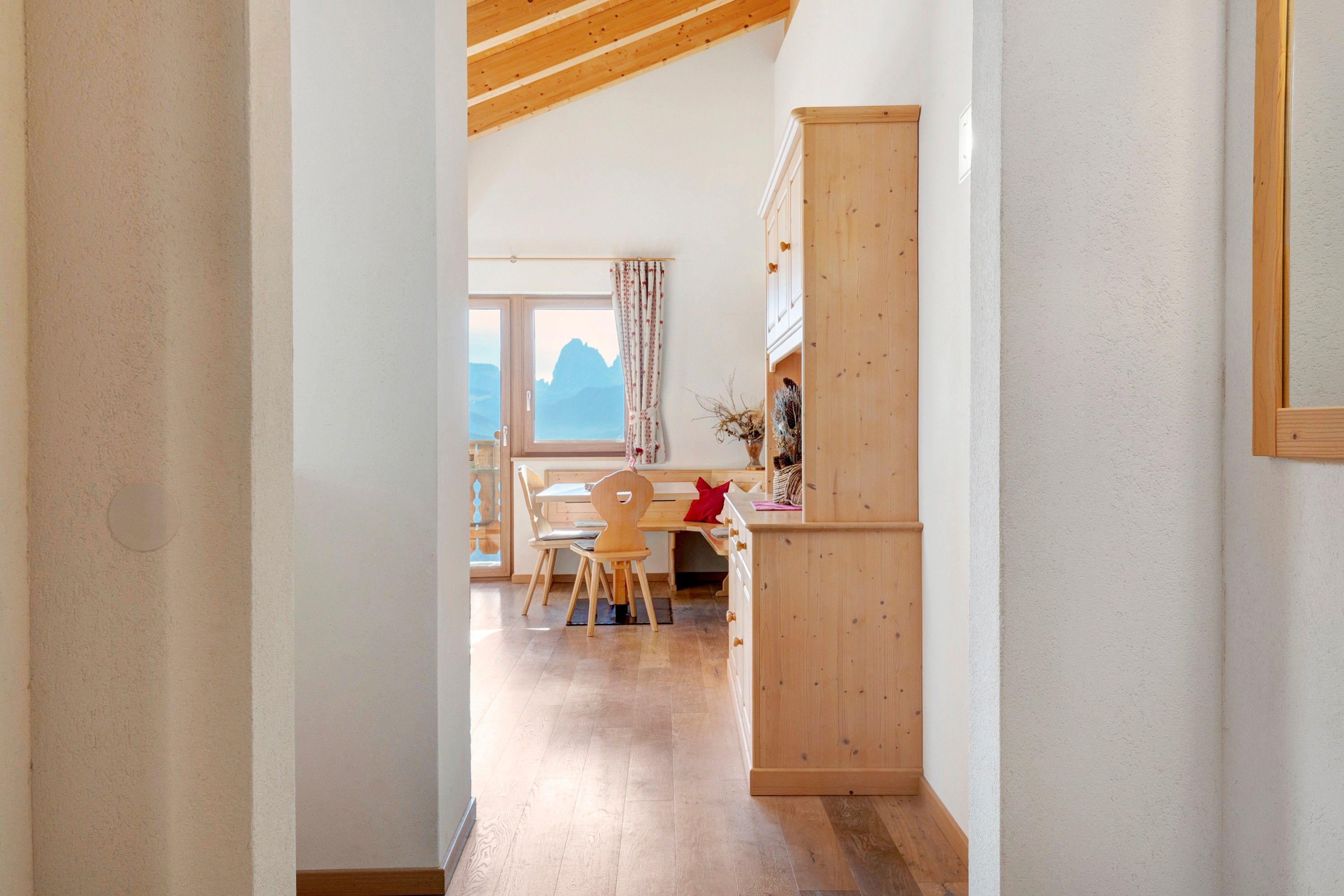 Un interior de madera con un comedor, una ventana con vistas y un armario.