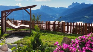 Un ensemble de jeux d’extérieur en bois, une clôture en bois et une vue sur les montagnes.