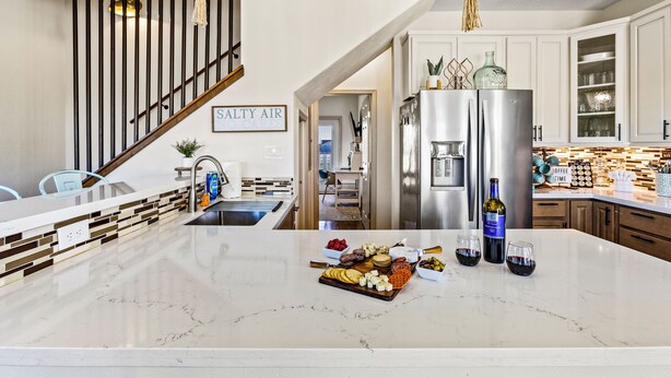 A modern kitchen with a marble countertop, stainless steel appliances, and a variety of food items. - Relaxing Beach Escape w/ Private Decks Walk2Beach (Galveston)