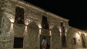 Un bâtiment en pierre doté d’un balcon, d’une porte et d’une fenêtre.