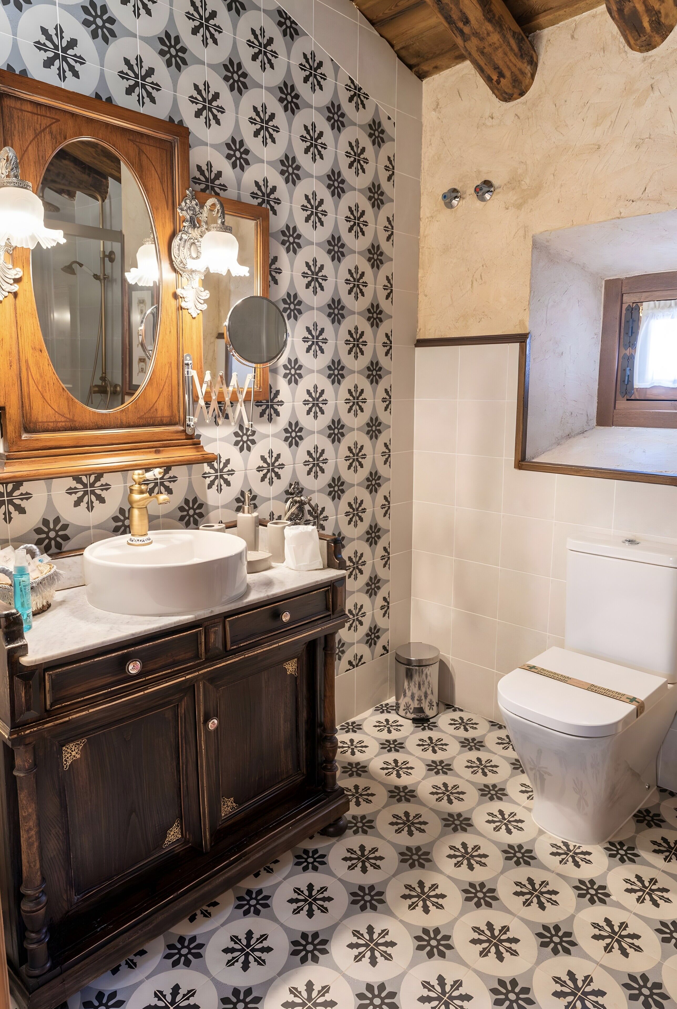 A bathroom with a wooden vanity, a large mirror, and a toilet.