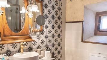 A bathroom with a wooden vanity, a large mirror, and a toilet.