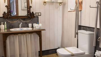 A bathroom with a checkered floor, a wooden vanity with a mirror, a toilet, and a shower area.
