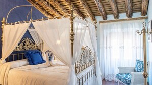 A four-poster bed with a canopy, a white chair, and a chandelier. - Room 'Leonor' with Shared Pool, Shared Terrace and Wi-Fi (Novés)