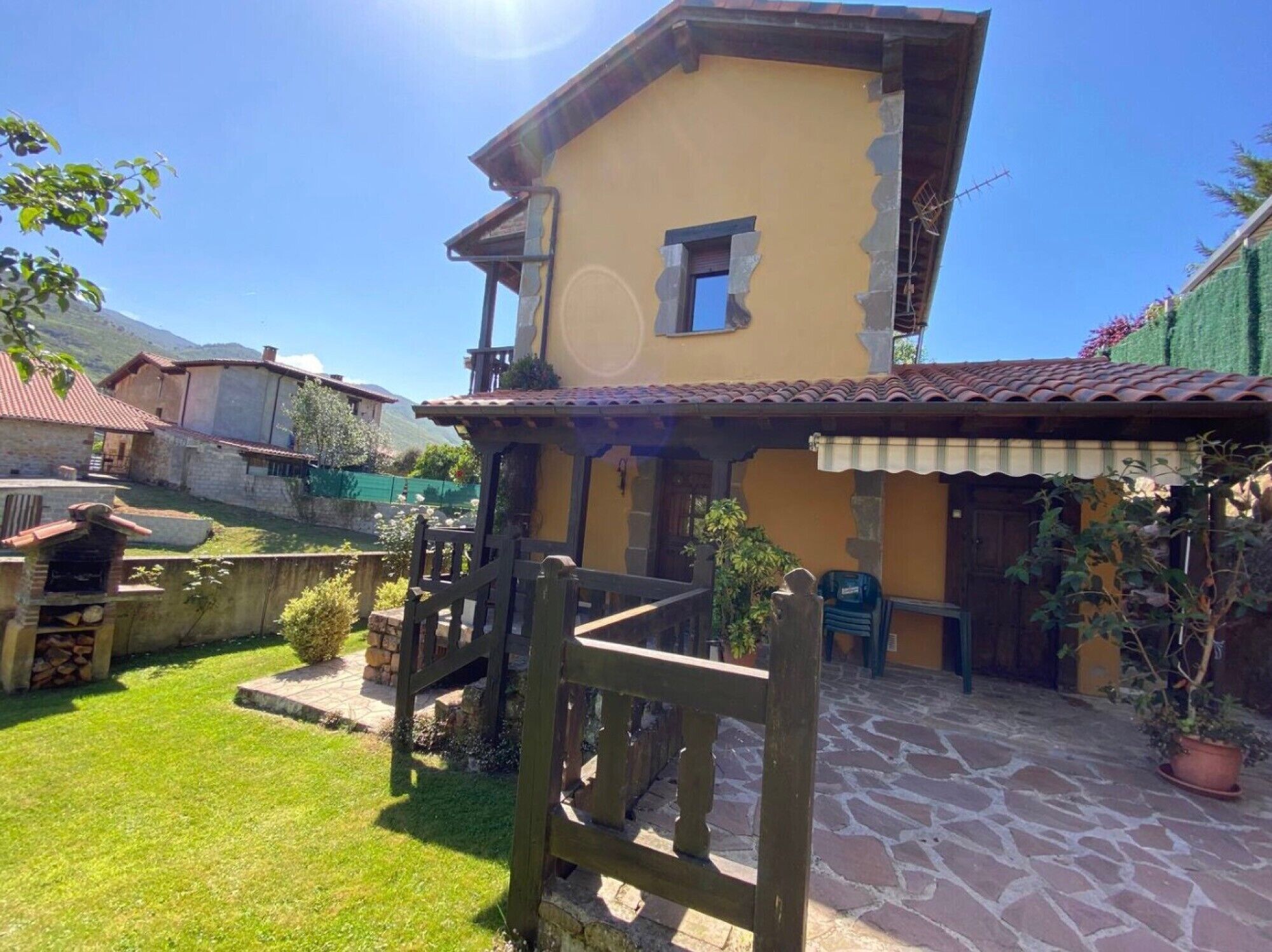 A two-story building with a stone-paved courtyard, a wooden fence, and a small window.