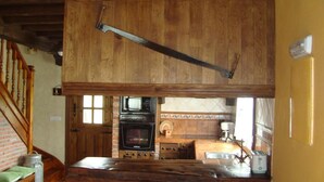 A kitchen with wooden cabinets, a brick oven, and a sink.