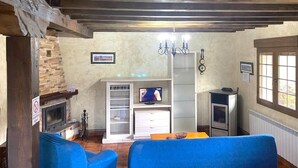 A living room with a fireplace, a television, and a dining area.