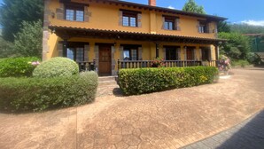 A two-story building with a yellow facade, stone accents, and a tiled roof.