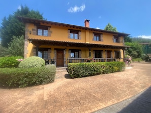 Un bâtiment à deux étages, doté d’une façade jaune, de détails en pierre et d’un toit recouvert de tuiles.