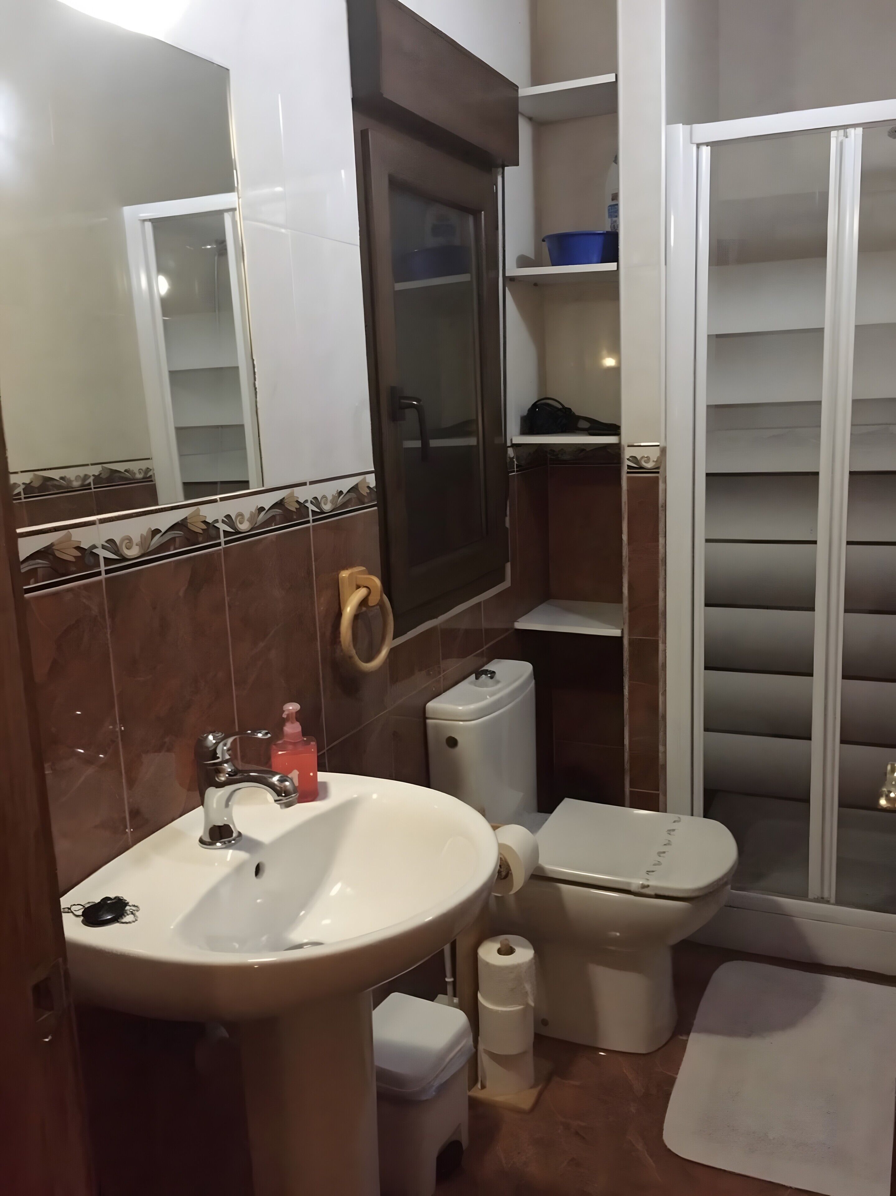 A bathroom with a sink, toilet, and shower.