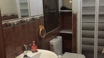 A bathroom with a sink, toilet, and shower.