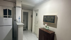 A kitchen with a refrigerator, a water dispenser, and a cabinet with a glass top. - HOTEL NASSMA residence  (Jijel)