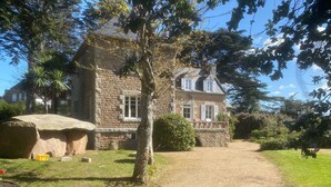 A stone building with a paved driveway and a large rock feature. - Villa 'Magnifique  À 80m Des Plages' with Private Terrace, Private Garden and Wi-Fi (Trébeurden)