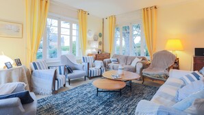 A living room with a sofa, armchairs, a coffee table, and a lamp. - Villa 'Magnifique  À 80m Des Plages' with Private Terrace, Private Garden and Wi-Fi (Trébeurden)