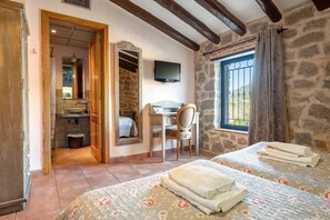 A bedroom with a bed, a desk, a chair, a TV, and a window with curtains. - Country House 'Mas Fullat' with Mountain View, Wi-Fi and Air Conditioning (Alforja)