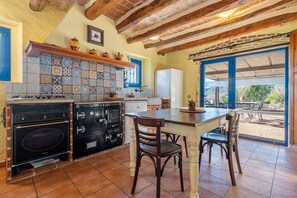 Une cuisine équipée d’une cuisinière, d’un four et d’une table à manger avec des chaises.