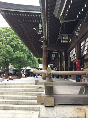 A traditional Japanese building with a wooden structure and a stone staircase leading up to it.
