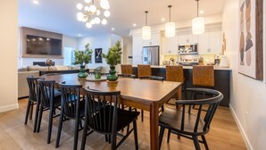 A modern kitchen with white cabinets, a central island, and pendant lighting.