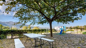 Un parc équipé de tables de pique-nique, d’une aire de jeux et offrant une vue sur les montagnes.