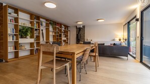 Een moderne woonkamer met een houten eettafel, stoelen en een inbouwkast.