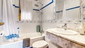 Une salle de bain avec une baignoire, des toilettes et un lavabo.