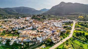 Vista aérea de un pueblo con edificios, carreteras y montañas al fondo.