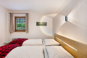 A bedroom with two beds, a window with curtains, a wall-mounted light, and a painting. - Apartment 'Leitner' with Mountain View, Private Terrace and Wi-Fi (Tiers)