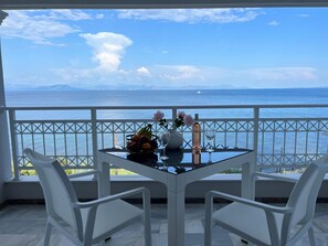 A balcony with a table, chairs, and a view of the sea. - Apartment 'Amaranth Rose' with Private Garden, Wi-Fi and Air Conditioning (Corfu)