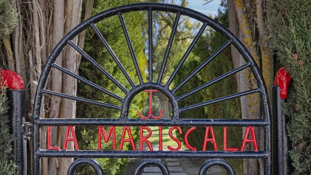 A wrought iron gate with the inscription 'LA MARISCALA' in red letters.