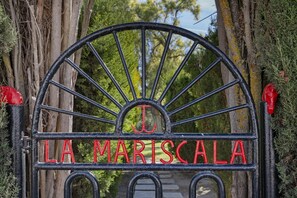 Un portail en fer forgé portant l’inscription « LA MARISCALA » en lettres rouges.