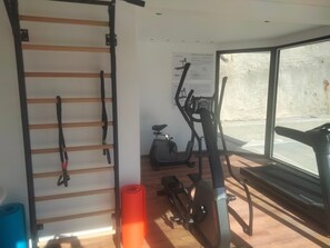 A gym with exercise equipment, a window, and a wall-mounted rack. - Apartment 'Pauli 6' with Mountain View, Shared Garden and Wi-Fi (Lagundo)