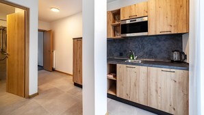 A modern kitchen with wooden cabinets, a built-in oven, and a sink. - Apartment 'Pauli 5' with Mountain View, Shared Garden and Wi-Fi (Lagundo)