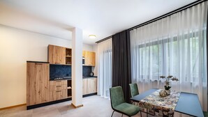 A modern dining area with a table, chairs, and a view through sheer curtains. - Apartment 'Pauli 5' with Mountain View, Shared Garden and Wi-Fi (Lagundo)