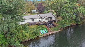 A lakeside house with a deck and a boat dock.