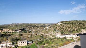 A rural landscape with buildings, a hill, and a clear sky.