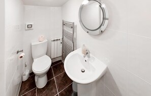 A modern bathroom with a toilet, bidet, and sink.