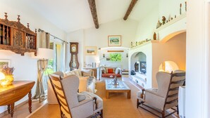 A spacious living room with a fireplace, wooden furniture, and a view of the outdoors. - Holiday Home “Mas Lis Amélie” with Mountain View, Wi-Fi and Air Conditioning (Eygalières)