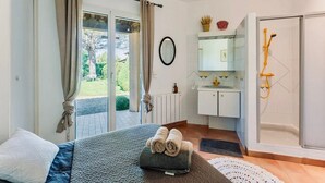 A bedroom with a bed, a bathroom with a shower, and a view of the outdoors. - Holiday Home “Mas Lis Amélie” with Mountain View, Wi-Fi and Air Conditioning (Eygalières)