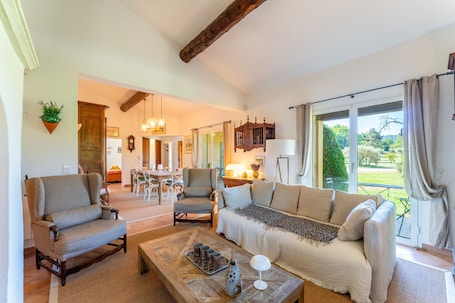 A spacious living room with a sofa, armchairs, a coffee table, and a dining area in the background.. Holiday Home “Mas Lis Amélie” with Mountain View, Wi-Fi and Air Conditioning