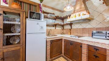 A kitchen with a refrigerator, microwave, sink, and a toaster.